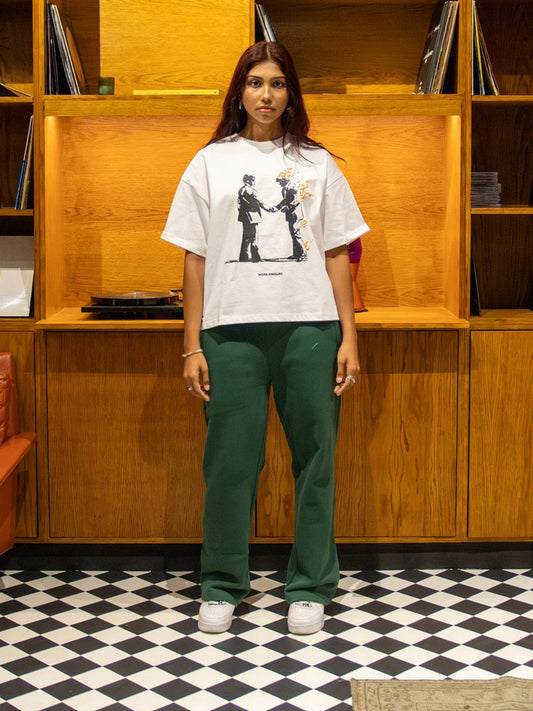 Person standing in a room with wooden bookshelves and vinyl records.