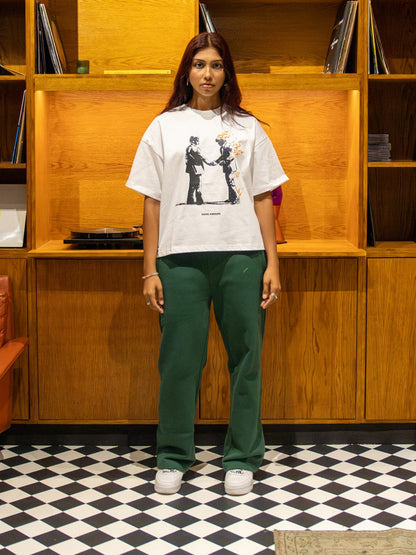 Person standing in a room with wooden bookshelves and vinyl records.
